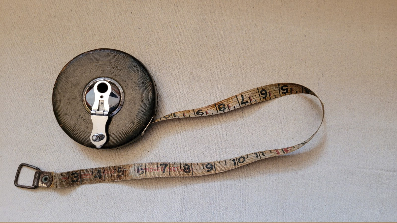 Vintage Lufkin Rule Co Canada tape measure with wind chrome hand crank and brown stitched leather, manufactured in Barrie, Ontario