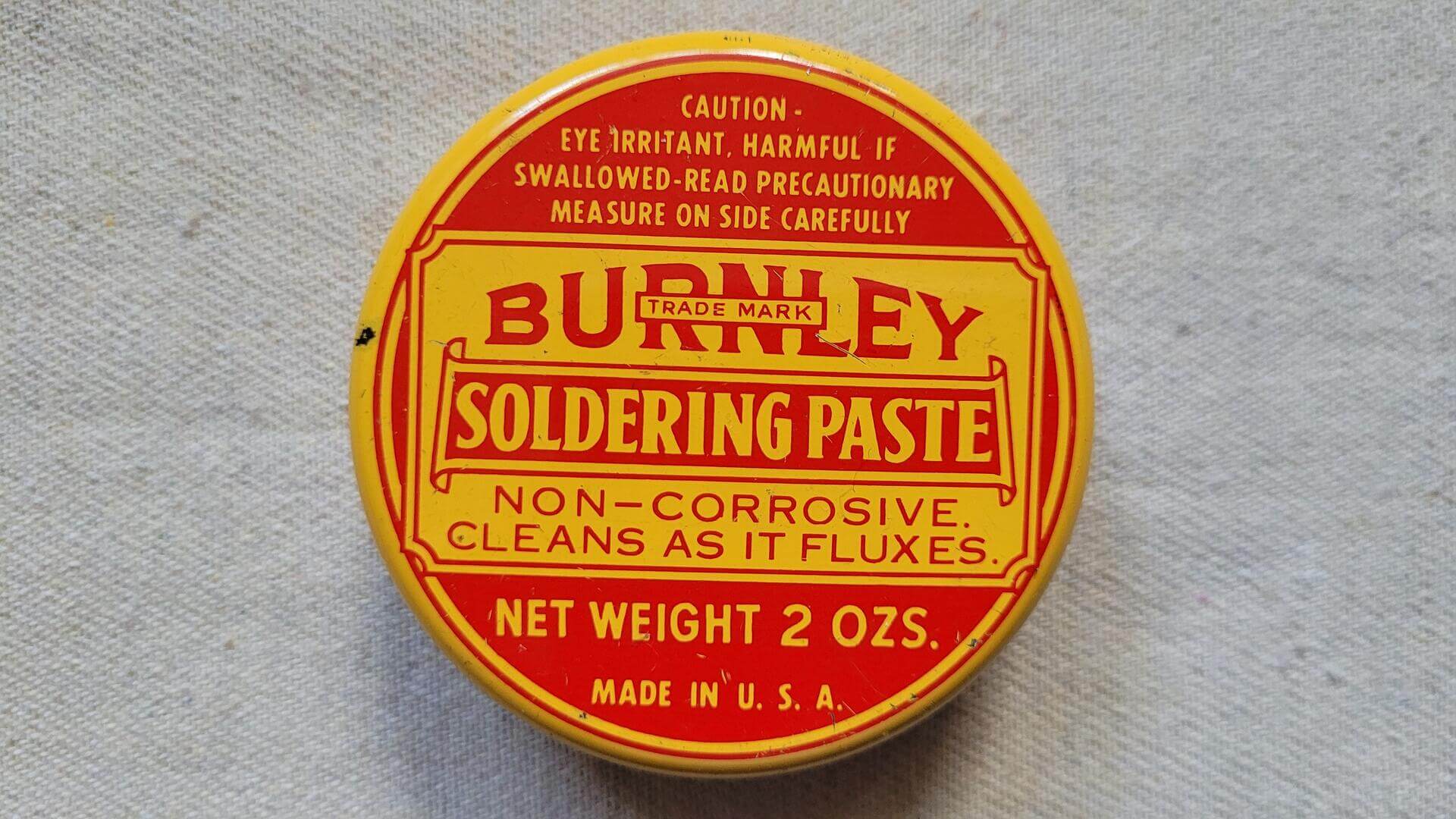 burnley-battery-mfg-co-soldering-paste-yellow-tin-can-2oz-north-west-pa-vintage-antique-made-in-usa-advertising-tin-container-collectibles-front
