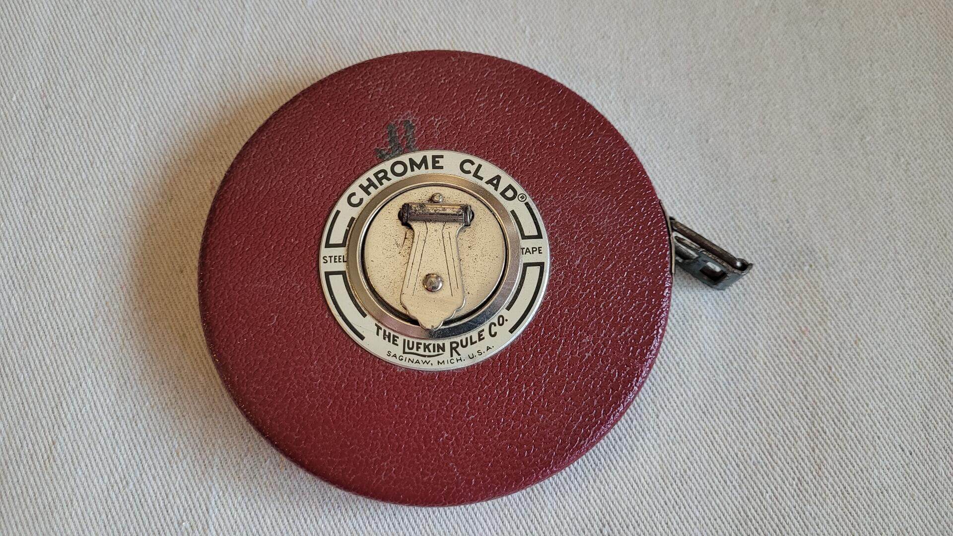 Vintage Lufkin Rule Co. 100' crome clad steel tape measure with Saginaw MI red leather case and Barrie ON chrome tape manufactured for Canadian market. Antique made in both USA and Canada collectible marking and measuring tool.