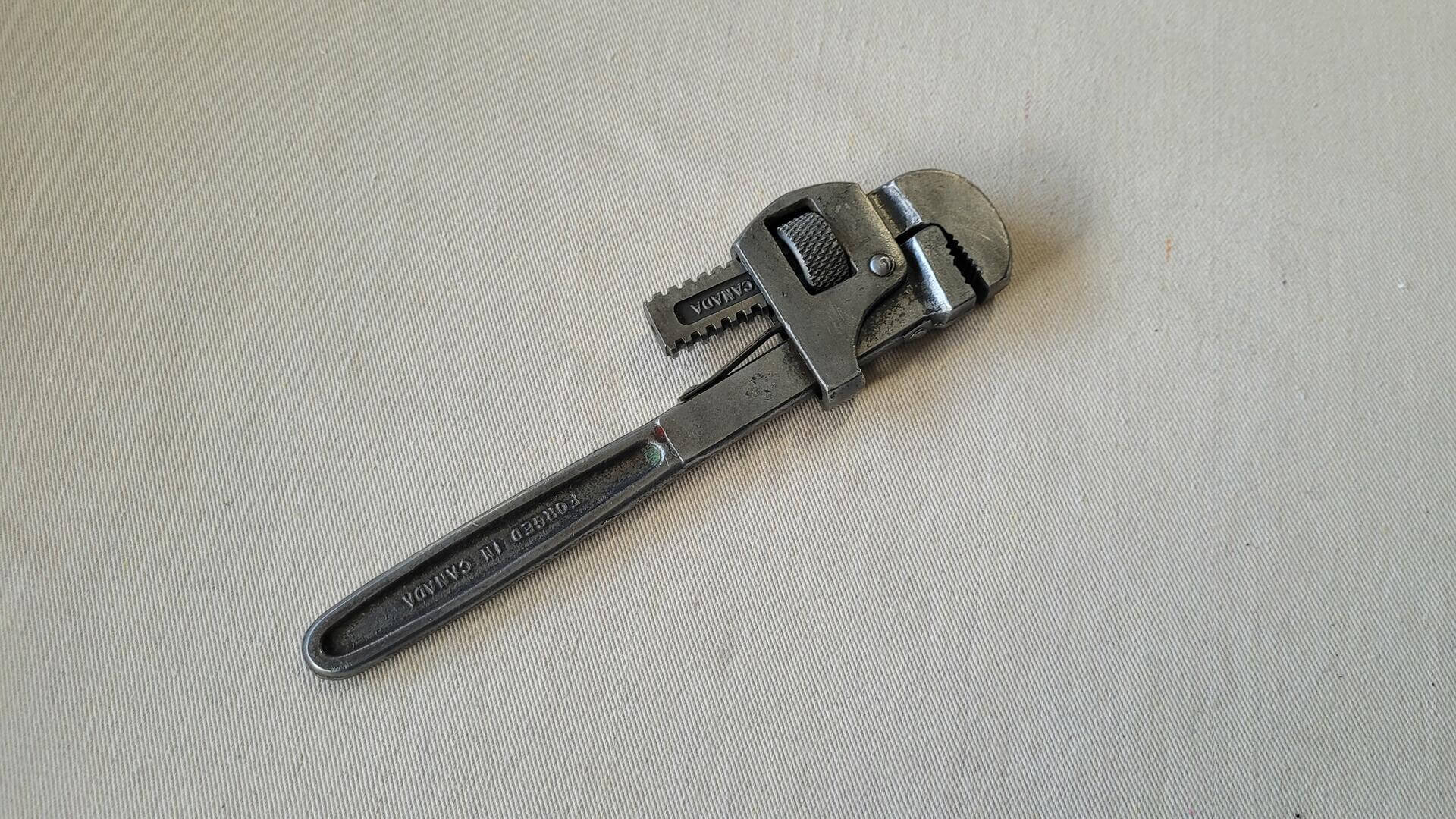Antique Stillson type adjustable 10 inch pipe wrench forged by McKinnon Industries St. Catharines, ON. Vintage made in Canada collectible plumbing tools