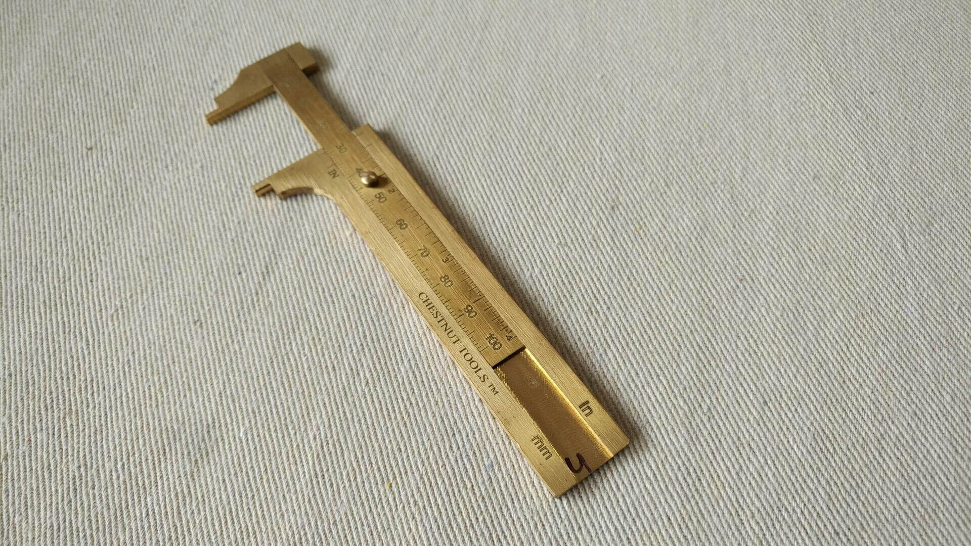 Solid brass inside and outside sliding mini caliper with both metric and imperial scales at 100mm or 4" capacity. Sized to fit in a shirt or apron pocket