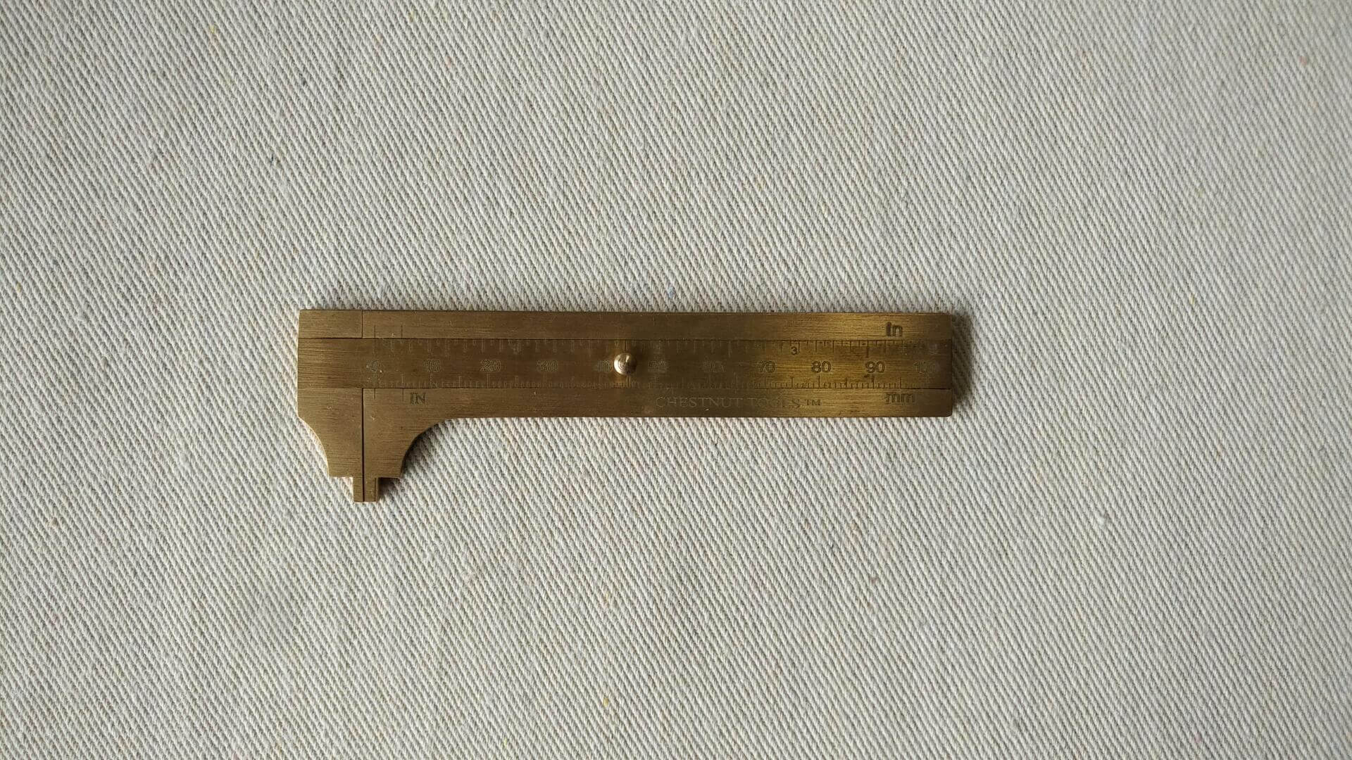 Solid brass inside and outside sliding mini caliper with both metric and imperial scales at 100mm or 4" capacity. Sized to fit in a shirt or apron pocket